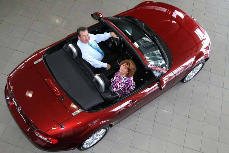 Arial view of man and woman sitting in convertible car.